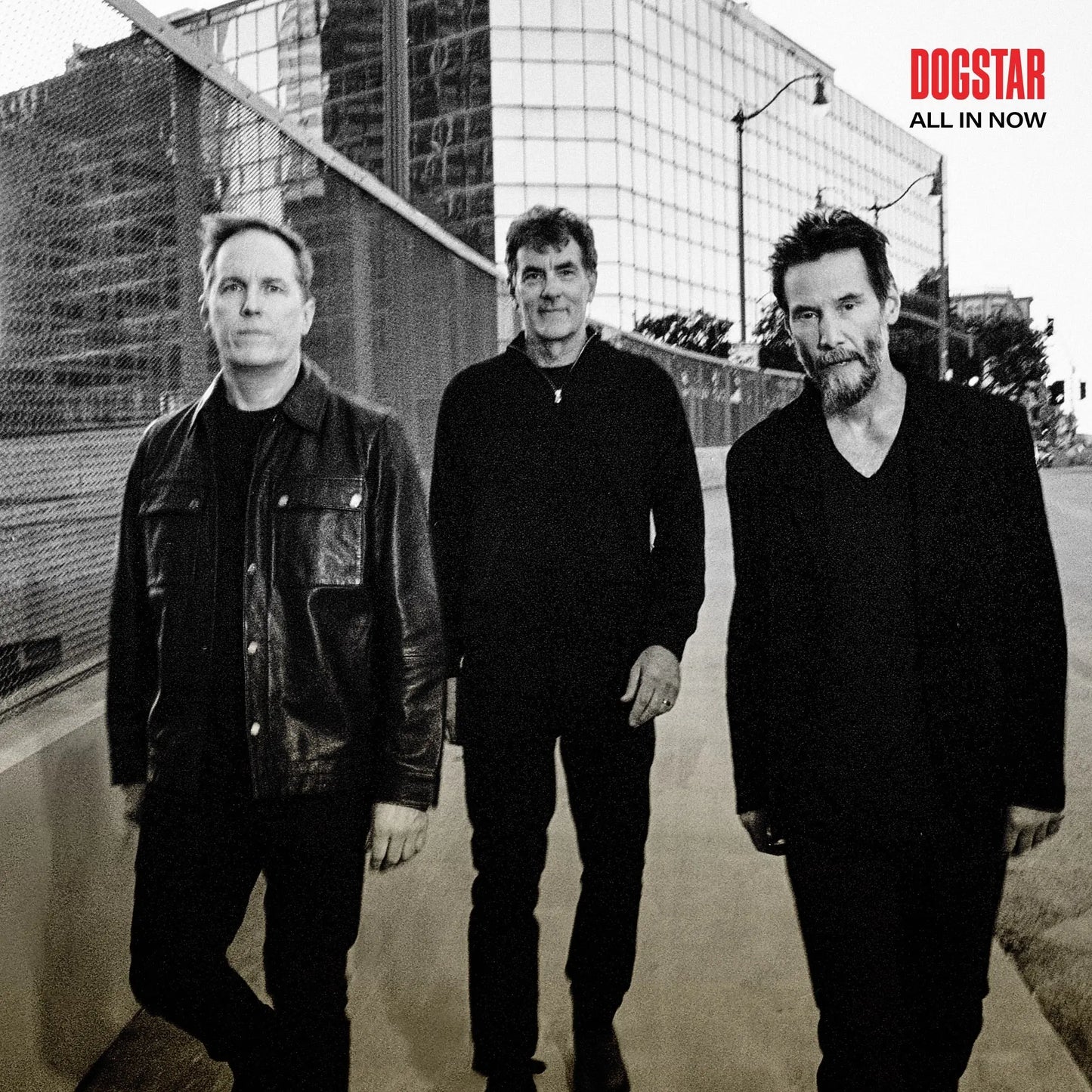 Dogstar - All In Now Three men standing on a street with a cityscape background, featuring the 'Dogstar' album cover text.
