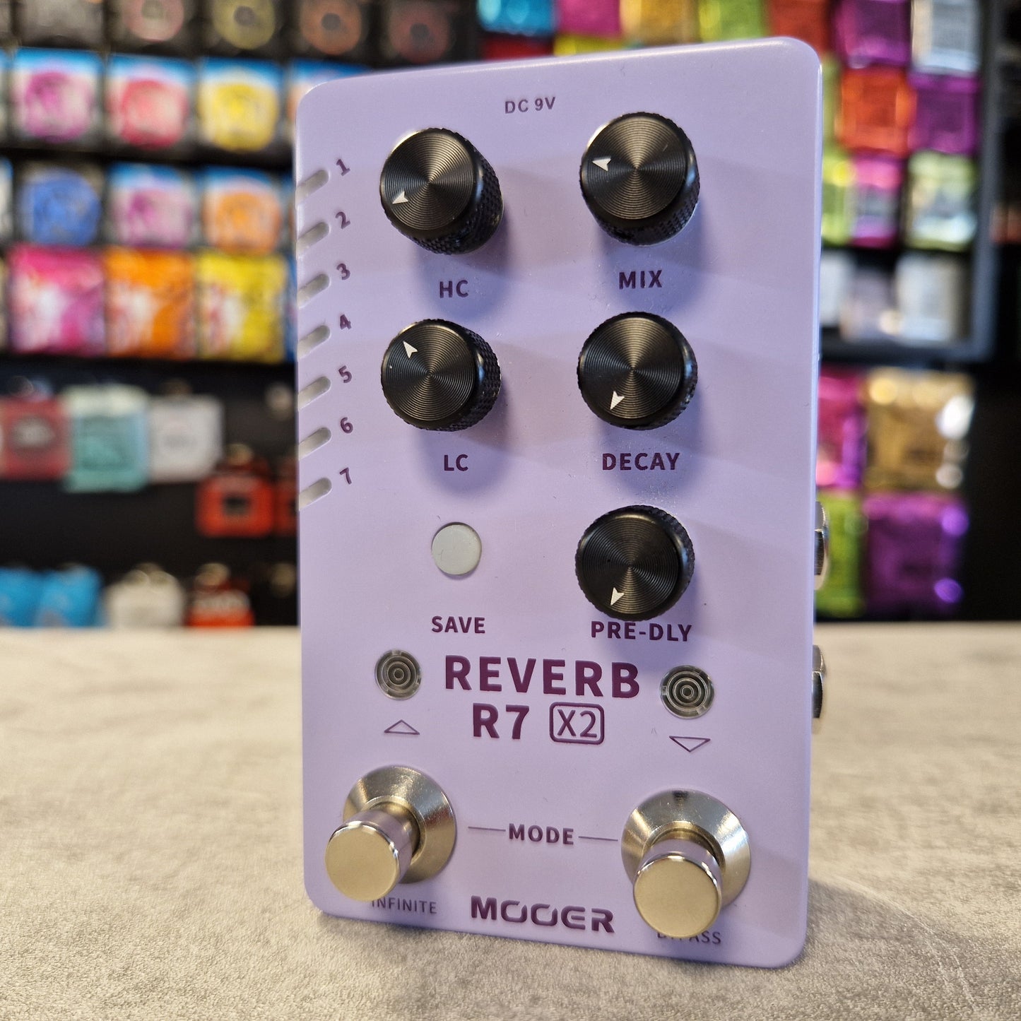 Mooer Reverb R7 X2 guitar effects pedal with a colourful store background