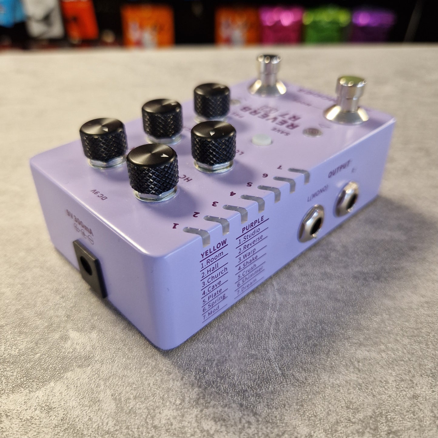 Mooer R7 X2 Purple audio effects pedal with knobs on a gray surface