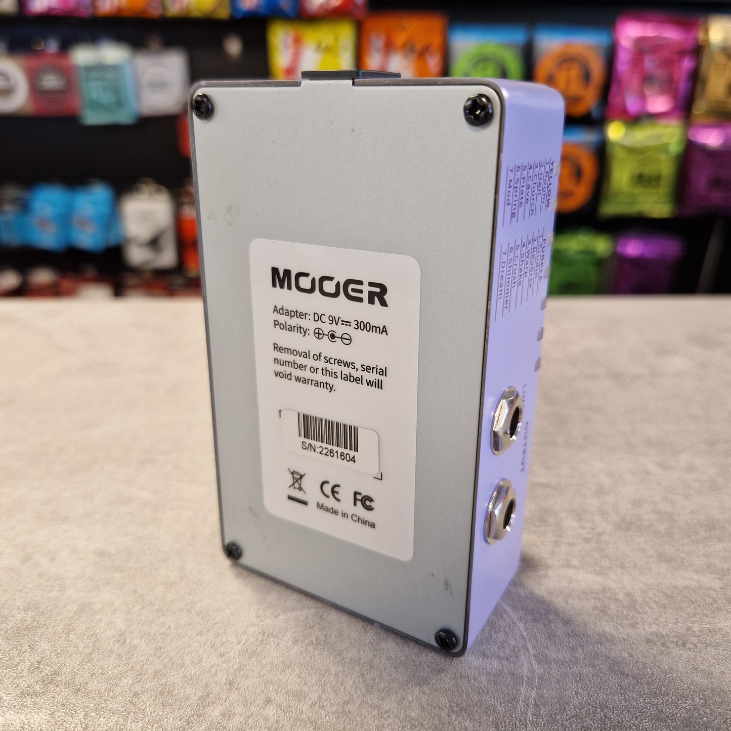 Mooer R7 X2 electronic component on a gray surface with colorful background
