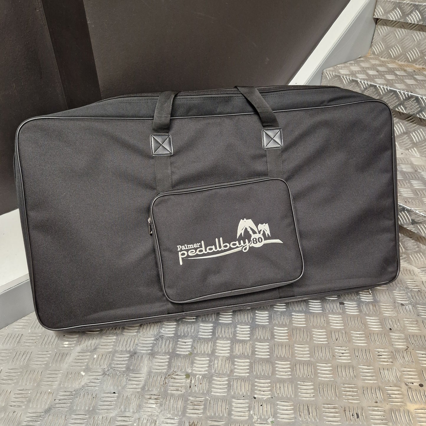 Pre-Owned Palmer Black carrying case with a logo on a textured surface