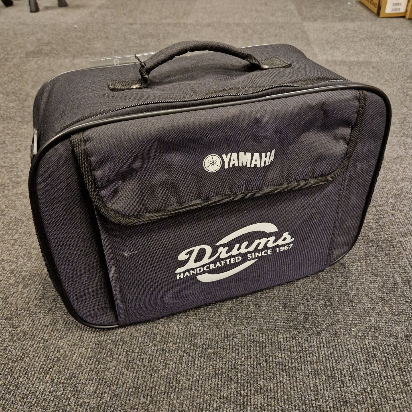 Pre-Owned Yamaha Black Yamaha drum case on a textured surface