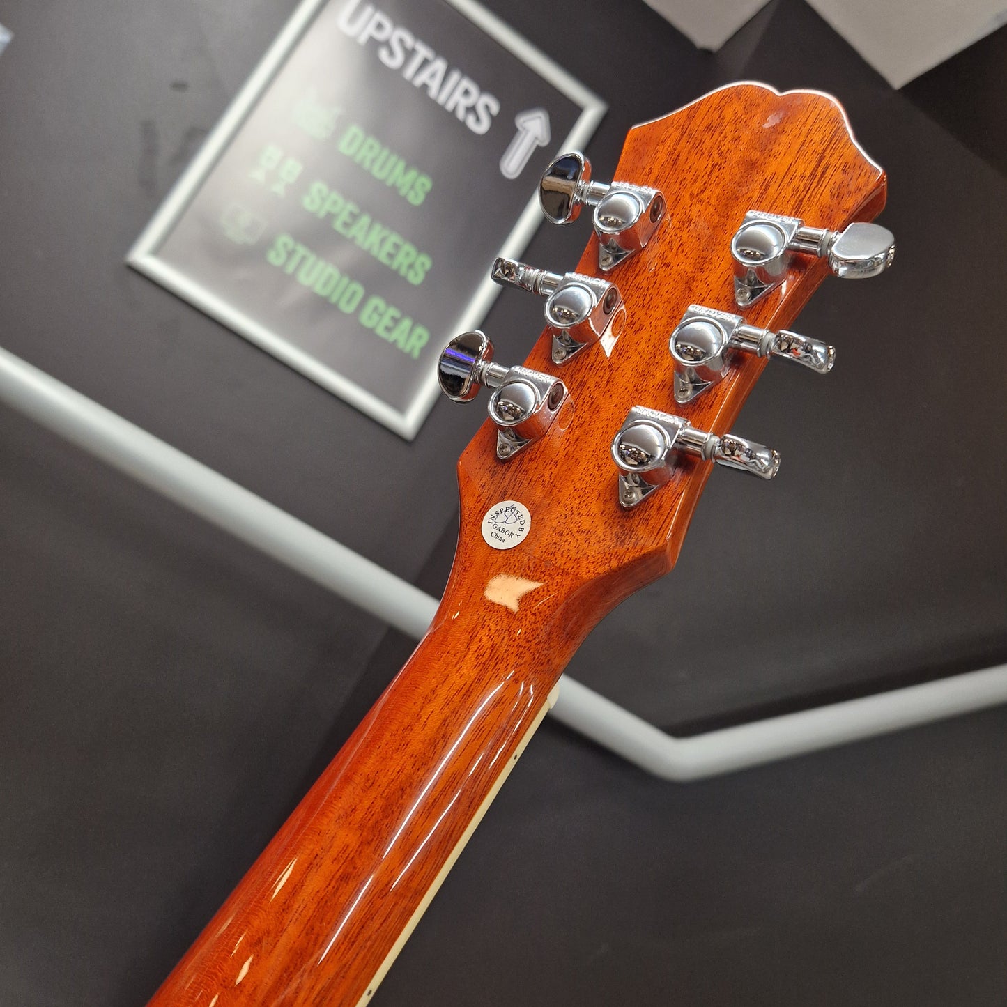 Pre-Owned Epiphone Close-up of a guitar headstock with tuning pegs on a blurred background