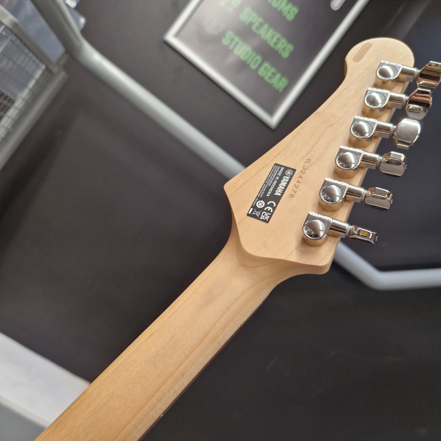 Pre-Owned Yamaha Guitar headstock with tuning pegs on a blurred background