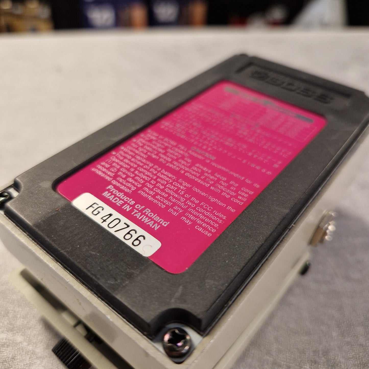 Pre-Owned Boss DD-3 Close-up of a Roland electronic device with a pink label on a blurred background