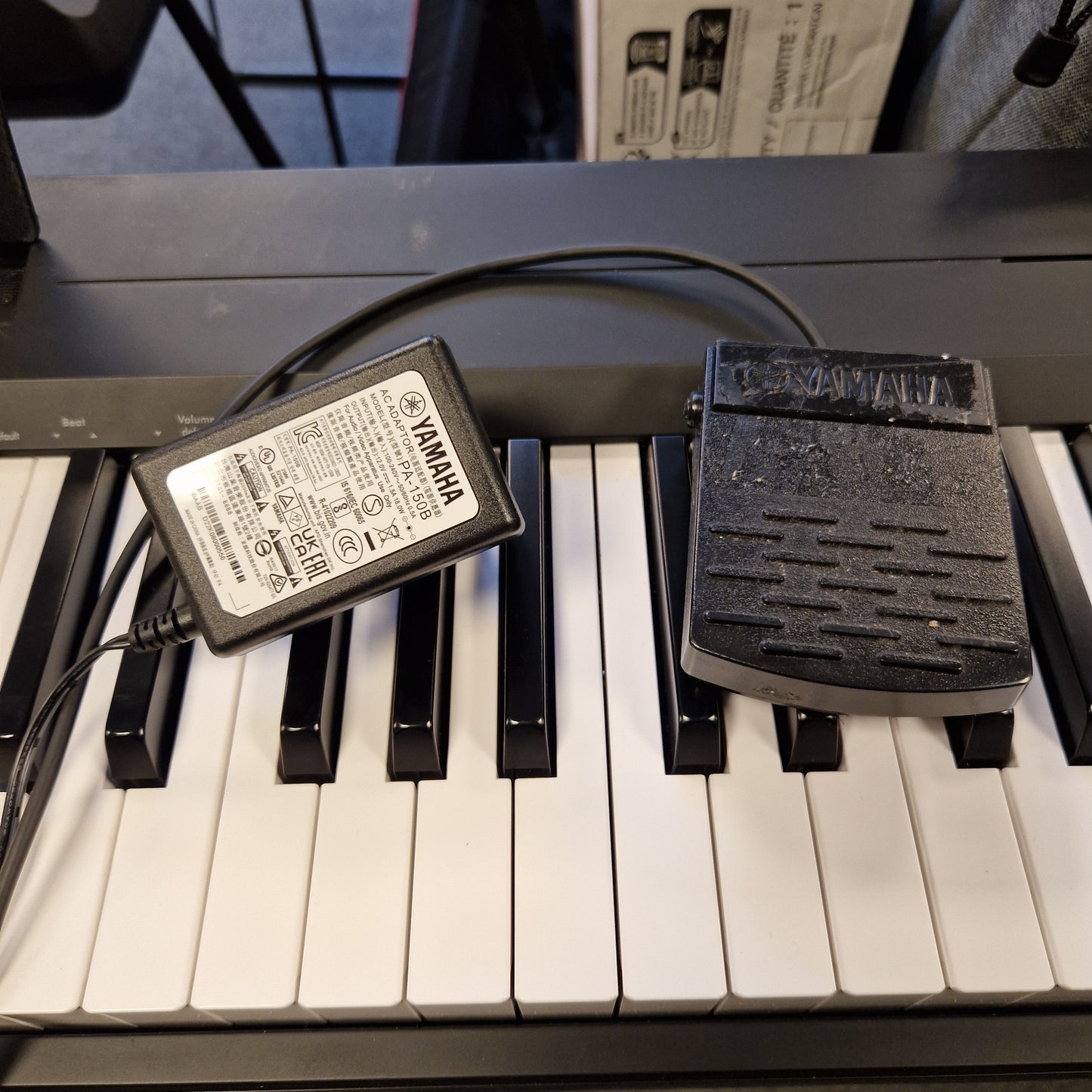 Pre-Owned Yamaha P-145B Yamaha power adapter attached to a keyboard with visible branding.