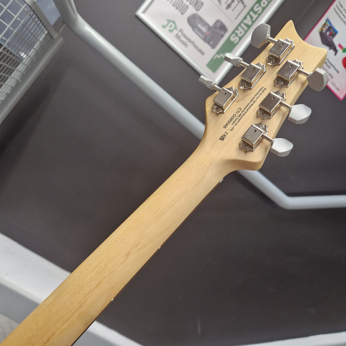 Pre-Owned PRS SE Silver Sky John Mayer Signature Electric - Dragonfruit w/ Gig Bag - Close-up of the headstock and neck of a light natural wood six-string electric guitar, showing six silver tuning pegs and printed model text on the back of the headstock.