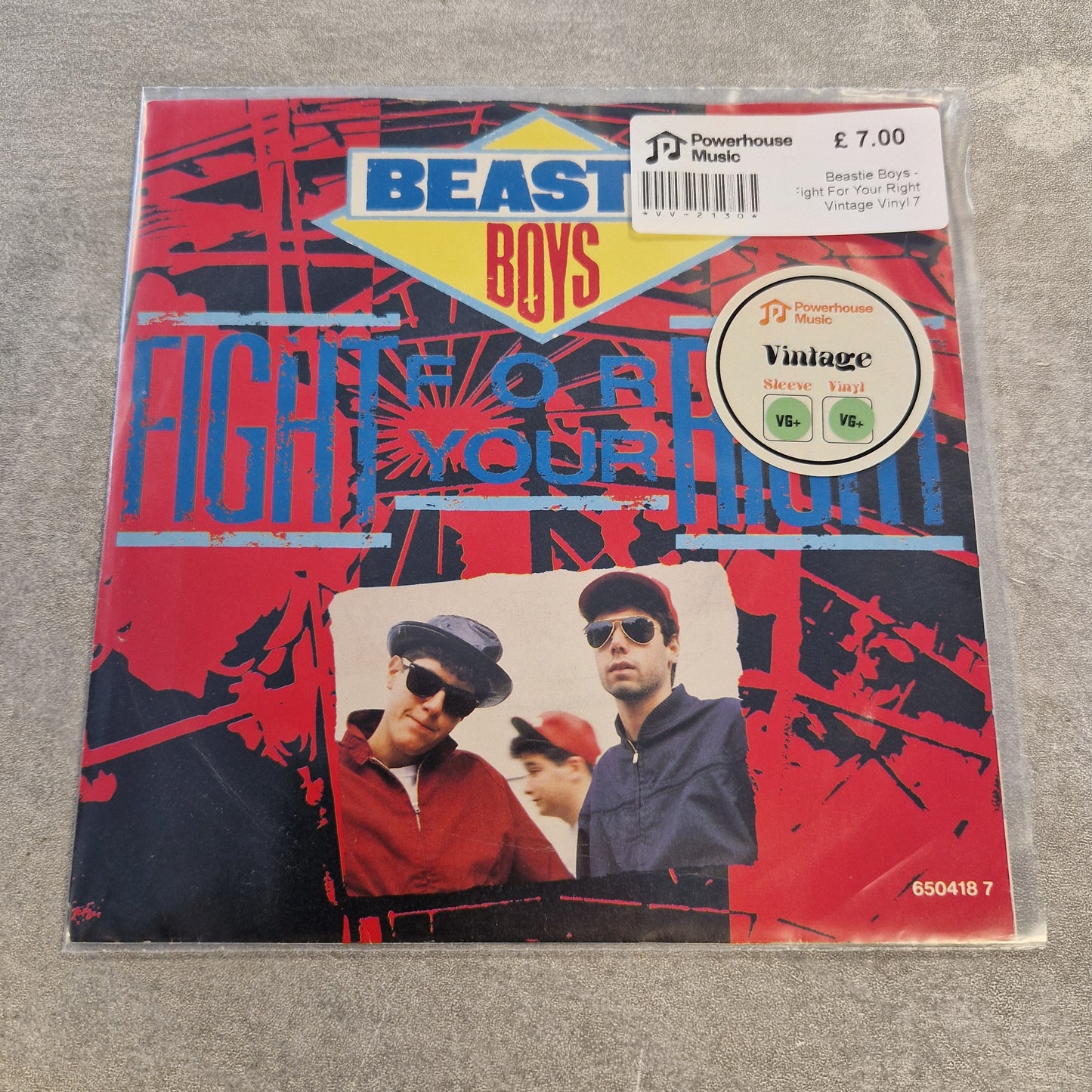 Beastie Boys - Fight For Your Right Vintage Vinyl 7" Single A physical copy of the Beast Boys 'Fight For Your Right' 7-inch vinyl record sleeve, sealed in a protective plastic sleeve with a Powerhouse Music sticker and barcode label on the top right.