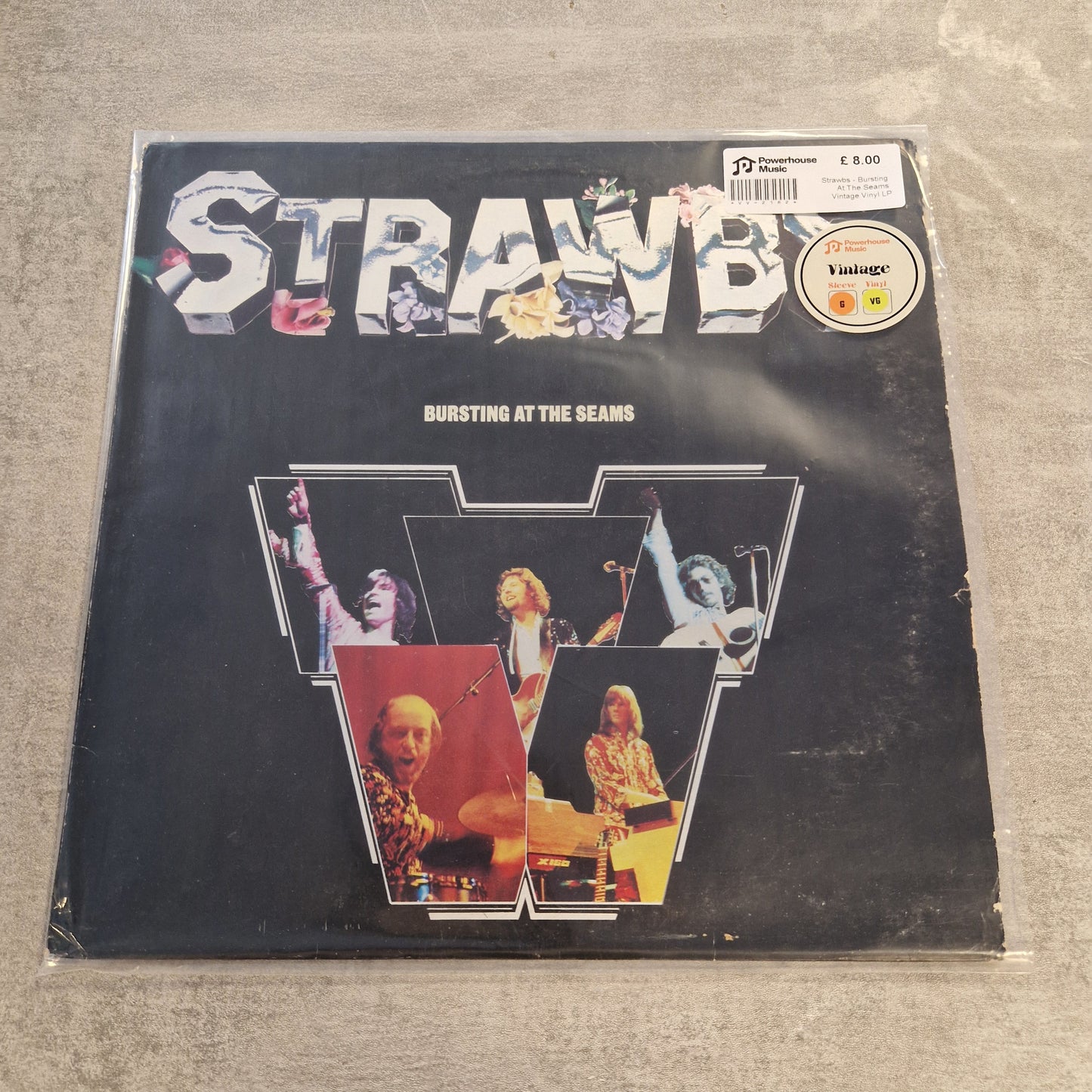 Strawbs - Bursting At The Seams Vintage Vinyl LP A vinyl record sleeve for the band Stray Kids' album 'Bursting at the seams', featuring a black background with a large stylized 'STRAYKIDS' logo and four photo panels inside a large 'W' shape. The sleeve is photographed on a gray concrete surface, with a 'Vintage' sticker and a barcode label visible in the top right corner.