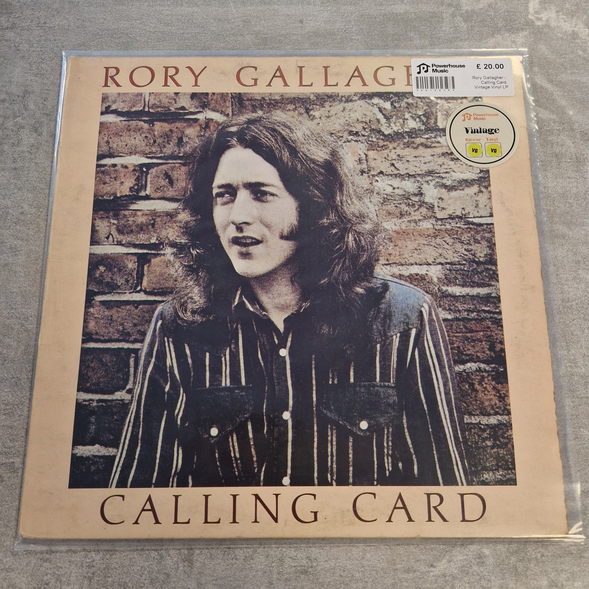 Rory Gallagher - Calling Card Vintage Vinyl LP Rory Gallagher 'Calling Card' vinyl record album cover, sealed in plastic with a barcode sticker and a Vintage record label sticker on the top right, photographed on a gray textured surface.
