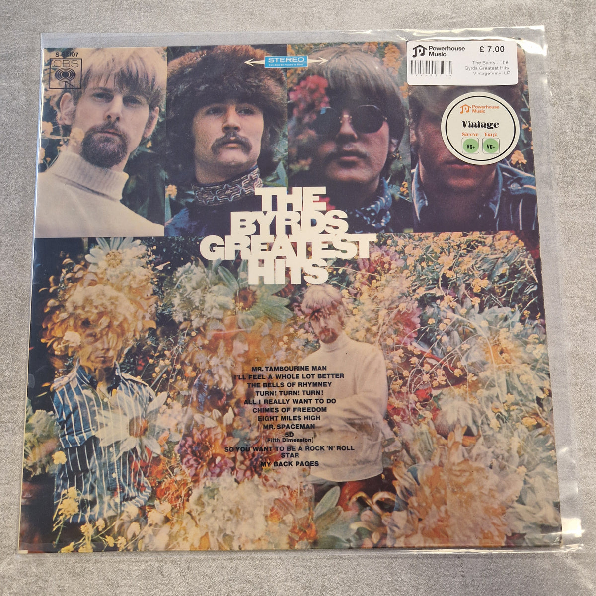 The Byrds - The Byrds Greatest Hits Vintage Vinyl LP The Byrds 'Greatest Hits' vinyl record album in its original shrink wrap, featuring a colorful collage cover with the band members and floral artwork. A 'JD Vintage' sticker is visible in the top right corner.