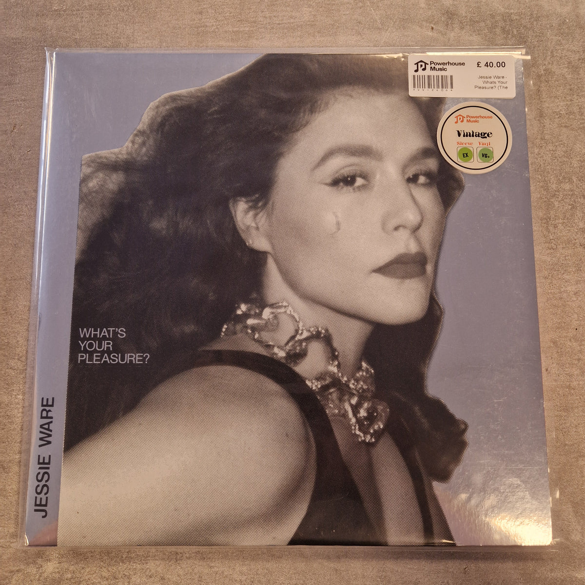 Jessie Ware - Whats Your Pleasure? (The Platinum Pleasure Edition) Vintage Vinyl LP Jessie Ware vinyl record cover for 'What's Your Pleasure?' on a textured gray surface, sealed in a protective plastic sleeve with a barcode sticker and a 2024 release sticker.