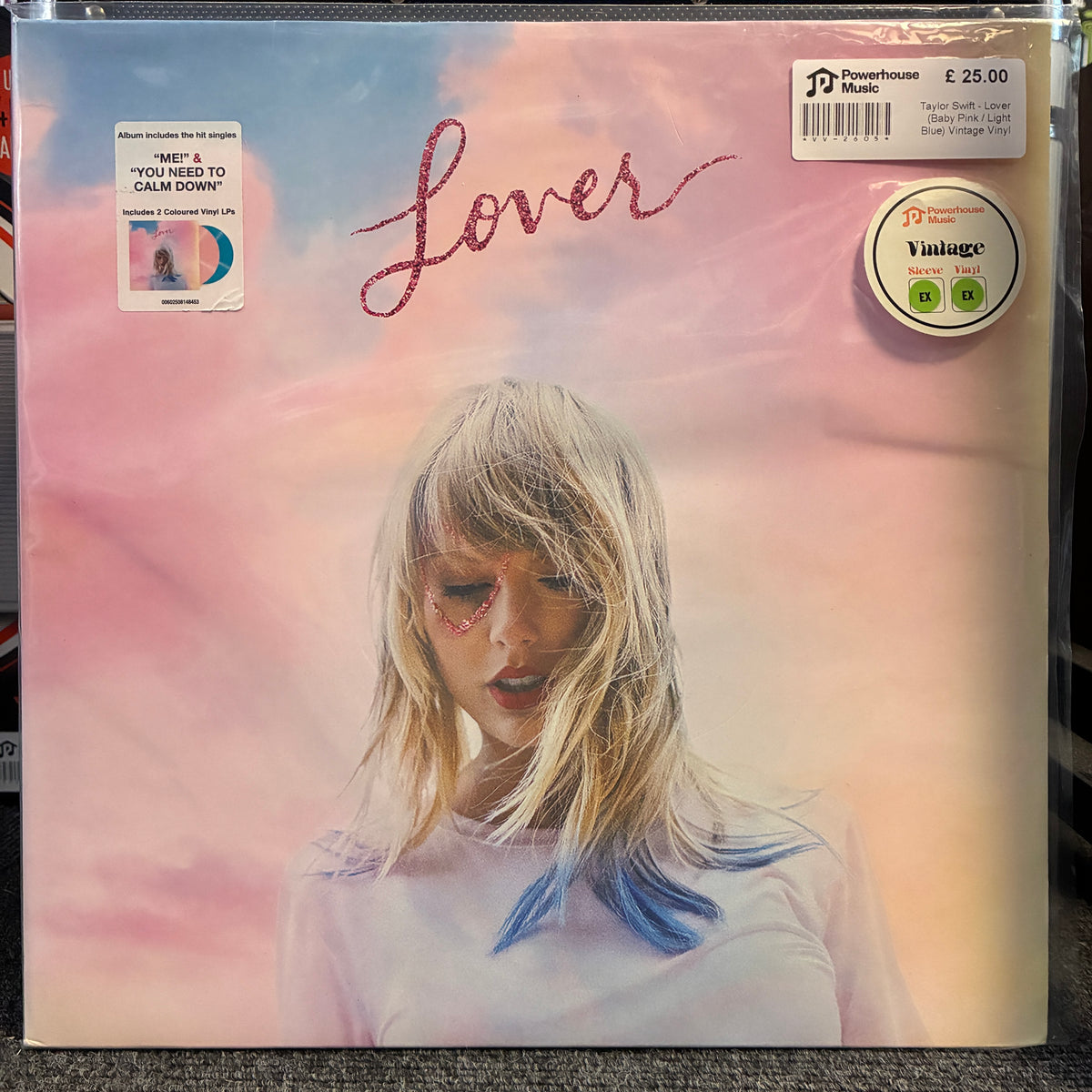 Taylor Swift - Lover (Baby Pink / Light Blue) Vintage Vinyl LP Taylor Swift 'Lover' vinyl record album cover, showing the blonde-haired artist against a pastel pink and blue sky background. The cover includes Powerhouse Music and Vintage stickers, and a price sticker in the top right corner.