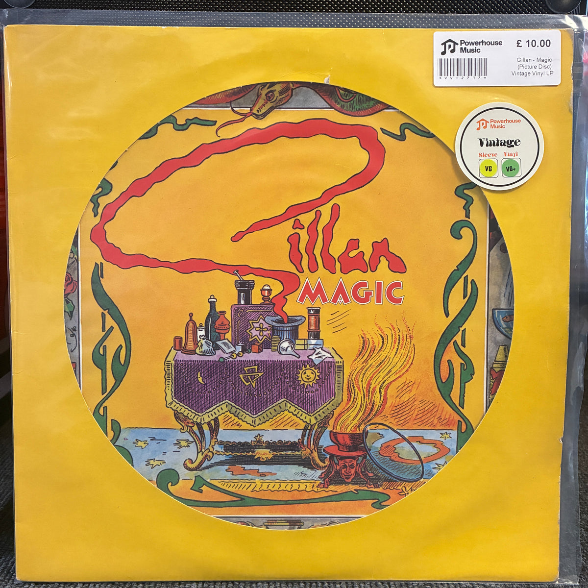Gillan - Magic (Picture Disc) Vintage Vinyl LP A vinyl record sleeve for the album 'Sillan Magic' by Powerhouse Music, featuring a bright yellow border and a central circular illustration with a purple table, red flame, and green decorative swirls. A Vintage 10-inch sticker is visible in the top right corner.