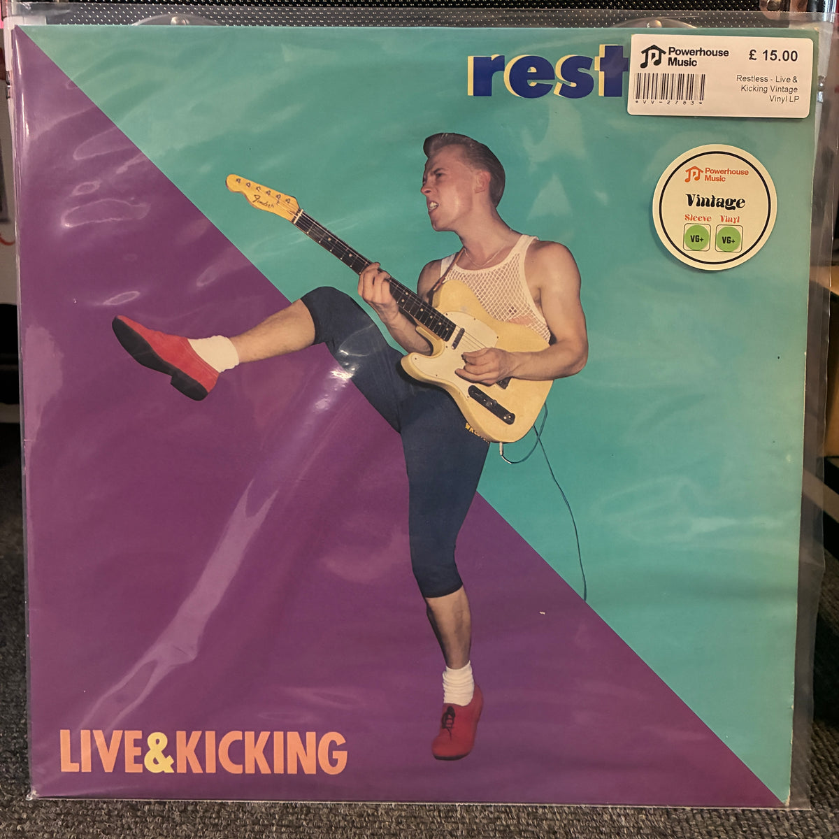 Restless - Live & Kicking Vintage Vinyl LP A vinyl record sleeve for the band 'rest' and album 'LIVE&KICKING', featuring a retro illustration of a man kicking while playing a guitar. The design has a diagonal split of purple and teal, with a prominent 'Vintage' logo sticker on the top right.