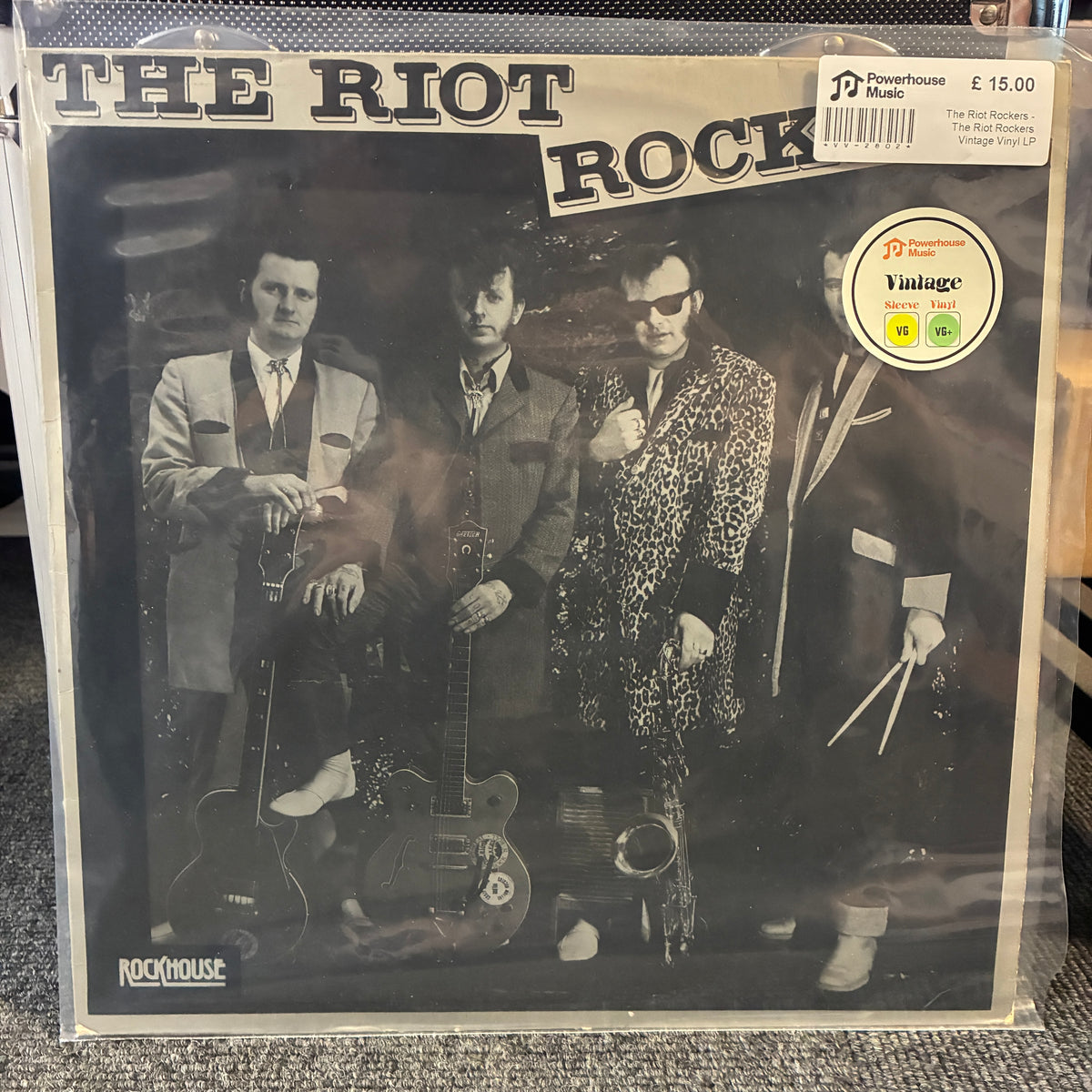 The Riot Rockers - The Riot Rockers Vintage Vinyl LP The Riot Rock - Rockin' Man in Four Suit jackets vinyl record LP in its clear plastic shrink wrap, featuring a black and white cover with the band members and instruments.