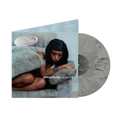 Nia Archives - Emotional Junglist A vinyl record album shown with its sleeve and a translucent gray record partially pulled from the case on a white background. The sleeve features a photo of a seated woman and the text 'Diva' and 'emotional junglists'.