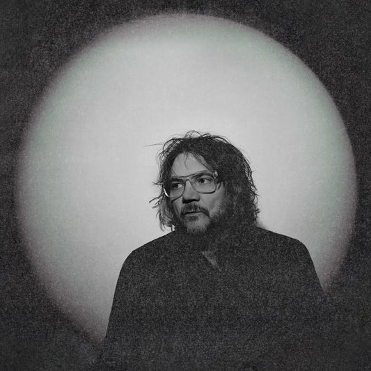 Jeff Tweedy - Twilight Override Man with glasses and beard against a circular light source