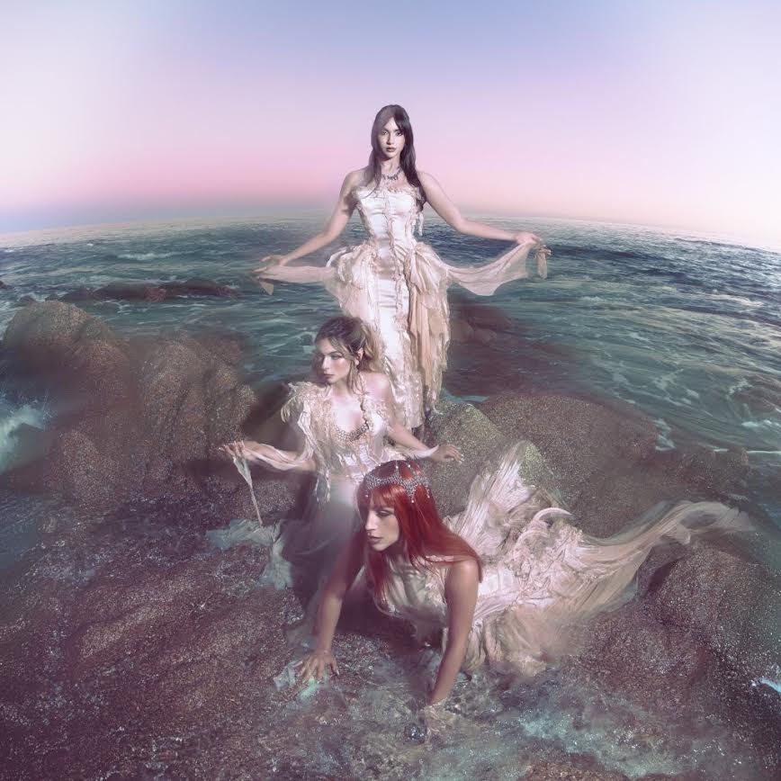 The Warning - Everything's Falling (Feather) Vinyl Three women in elegant dresses standing on rocks with a gradient sky.