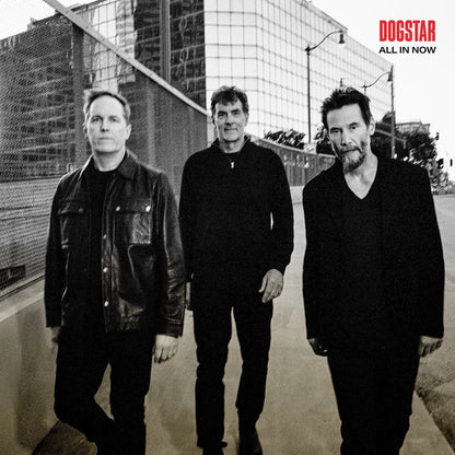 Dogstar - All In Now Three men standing on a street with a cityscape background, featuring the 'Dogstar' album cover text.