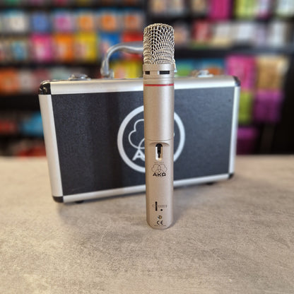 AKG C1000S  Microphone with a case on a textured surface with colorful background