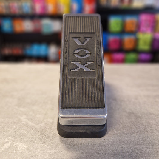 Vox V847 Metallic 'VOX' keychain on a textured surface with colourful background