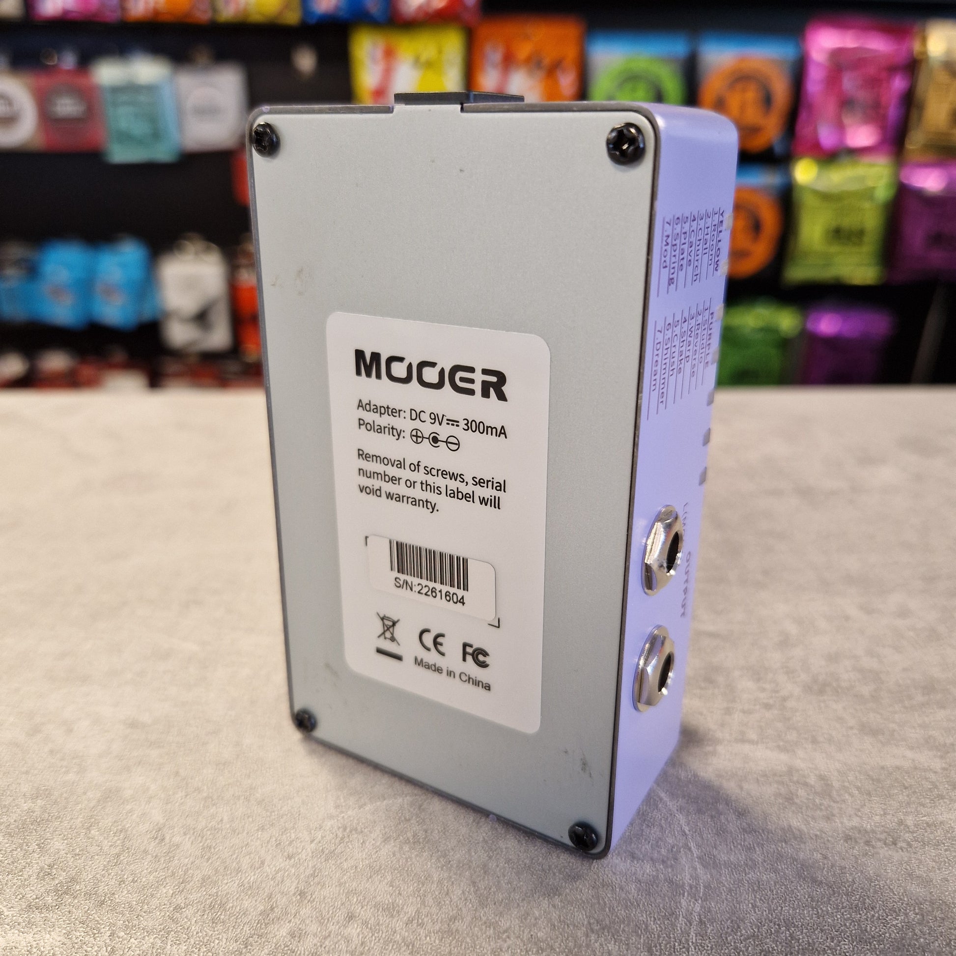 Mooer R7 X2 electronic component on a gray surface with colorful background