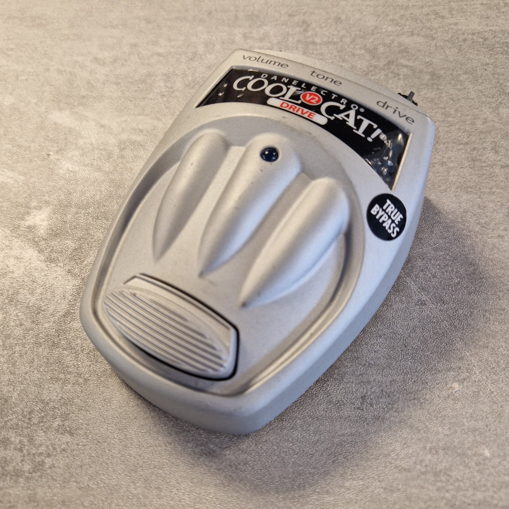 Danelectro Cool Cat V2 Drive White electronic device with 'Cool Cat' branding on a gray surface