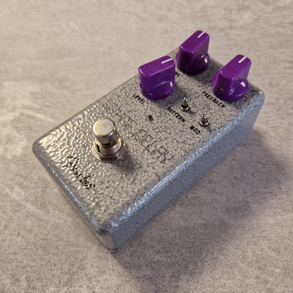 Fender Hammertone Space Delay Silver guitar effects pedal with purple knobs on a beige surface
