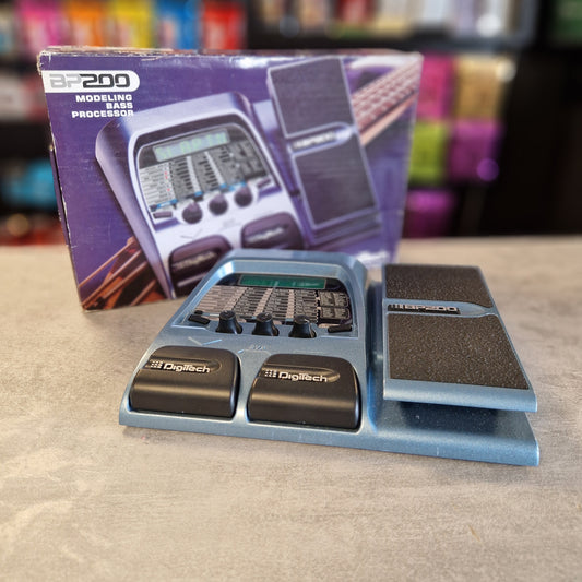 DigiTech BP200 pedal on a beige surface with a guitar pedal box in the background
