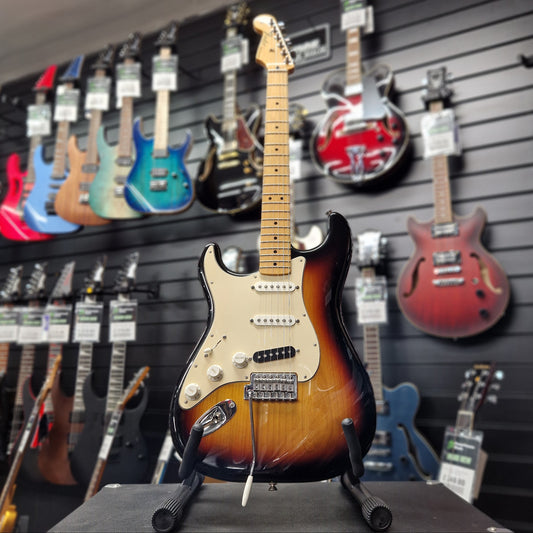 Pre-Owned Fender Mexican Guitar on display with other guitars in the background