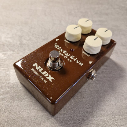 Pre-Owned NUX Guitar effects pedal with 'Nux' branding on a textured surface