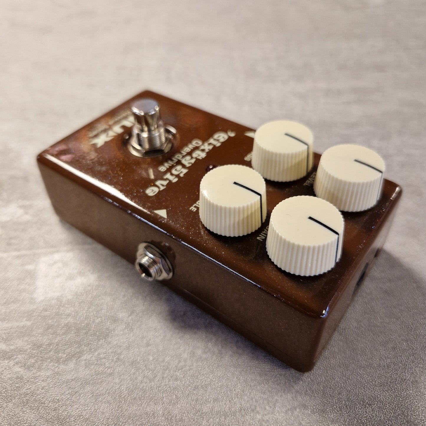 Pre-Owned NUX Guitar effects pedal with four knobs on a textured surface