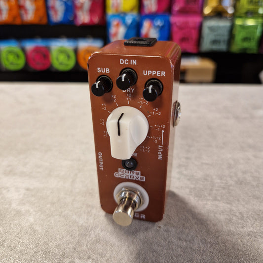 Pre-Owned Mooer Guitar effects pedal on a grey surface with colourful boxes in the background