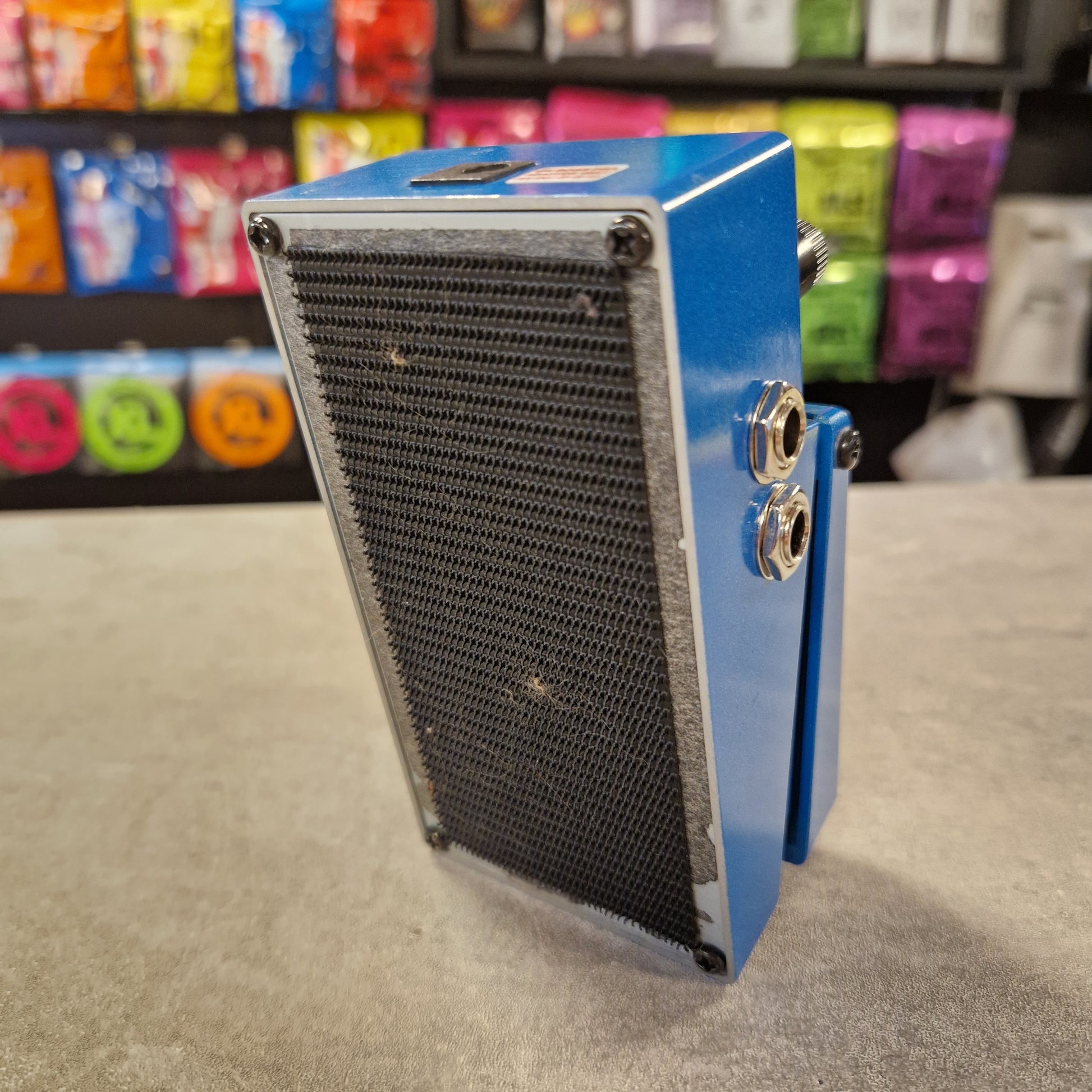 Pre-Owned Boss Blue and black radiator mounted on a wall with colourful objects in the background