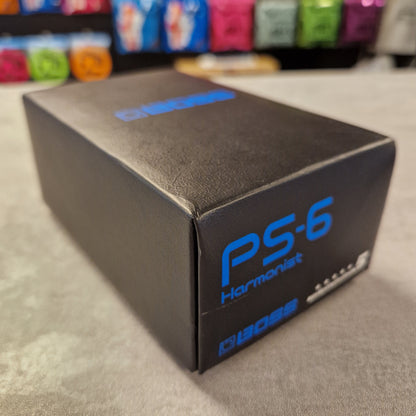 Pre-Owned Boss Black box with blue text on a grey surface