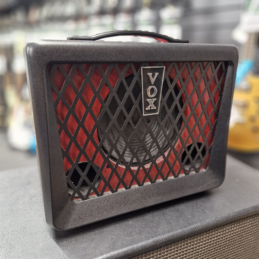 Pre-Owned Vox Small VOX amplifier with a red grille on a blurred background