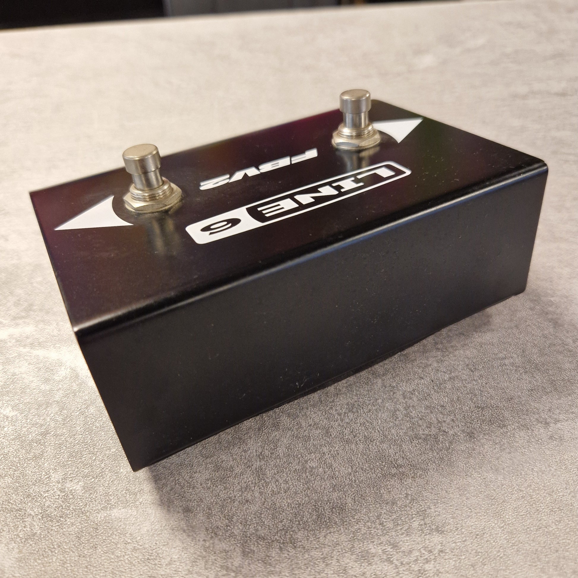 Pre-Owned Line 6 Black metal foot pedal with two knobs on a grey background