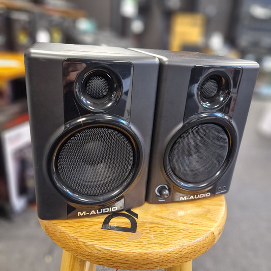 Pre-Owned M-Audio AV40 Studio Monitors Pair of M-Audio studio monitors with wooden finish on a blurred background