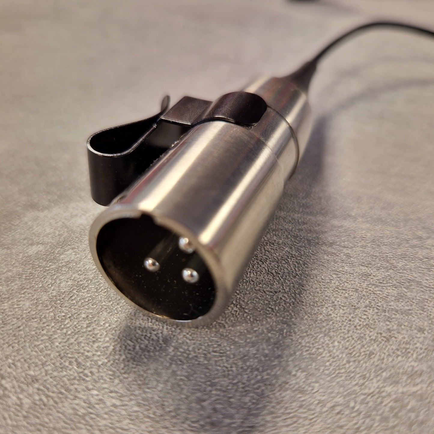 Pre-Owned Shure WH20XLR Headset Microphone - XLR Metallic microphone connector on a textured surface