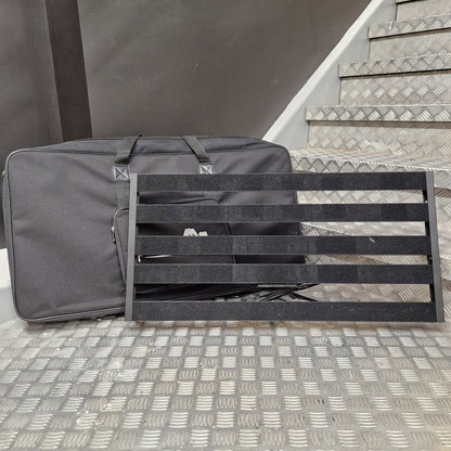 Pre-Owned Palmer Gray bag with black straps against a textured wall