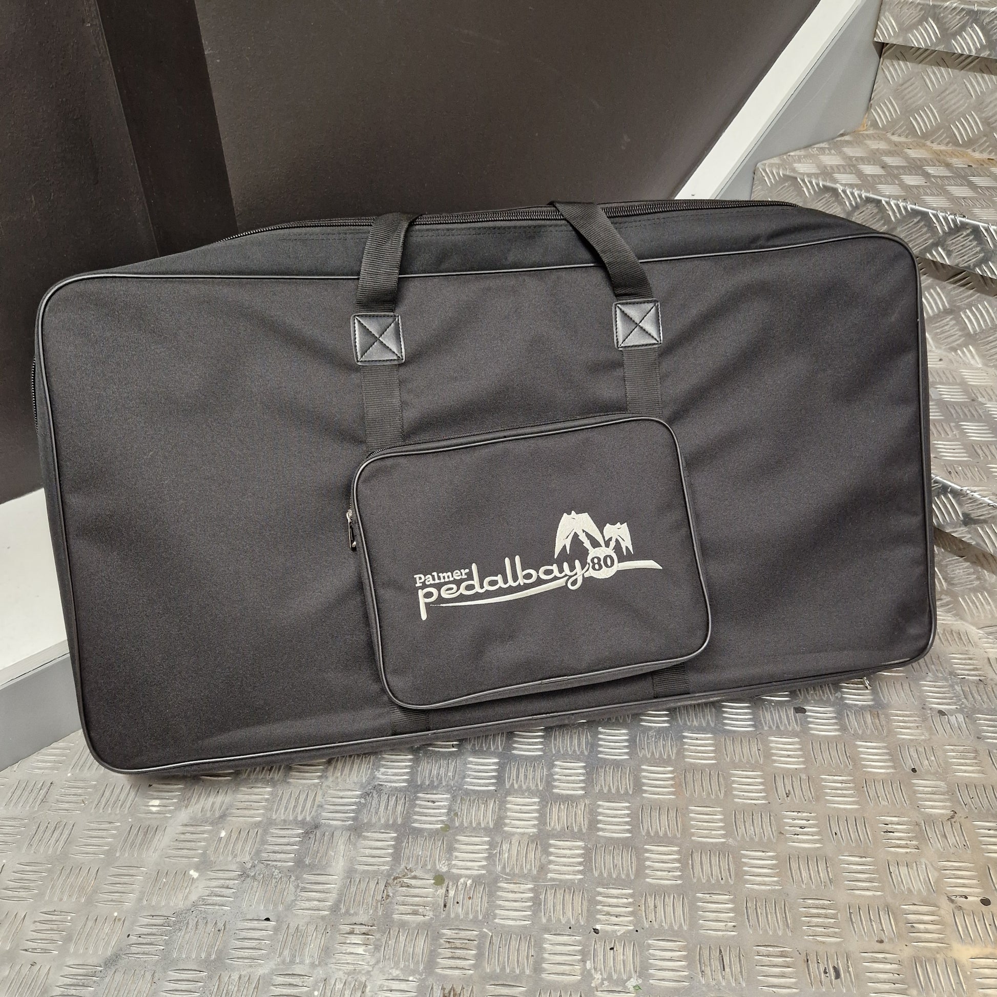 Pre-Owned Palmer Black carrying case with a logo on a textured surface