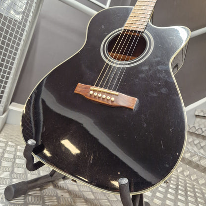 Pre-Owned Cruiser Black acoustic guitar on a stand with a blurred background