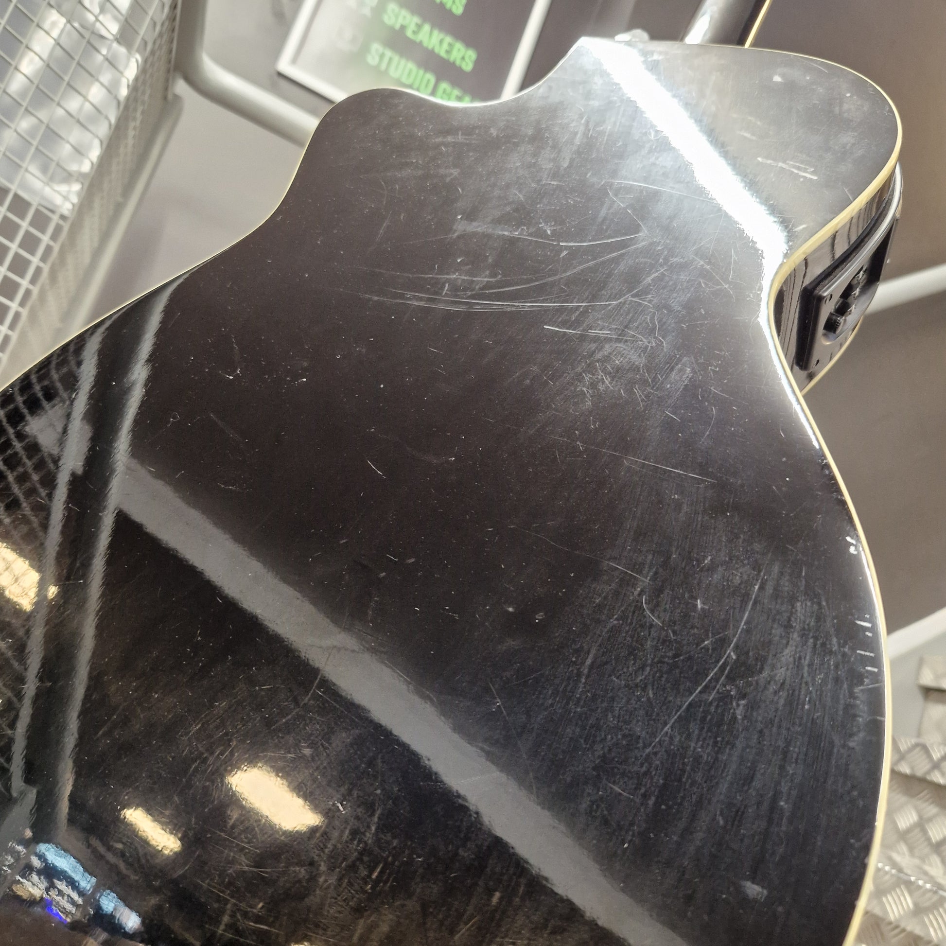 Pre-Owned Cruiser Close-up of a black guitar pickguard with visible wear and tear.