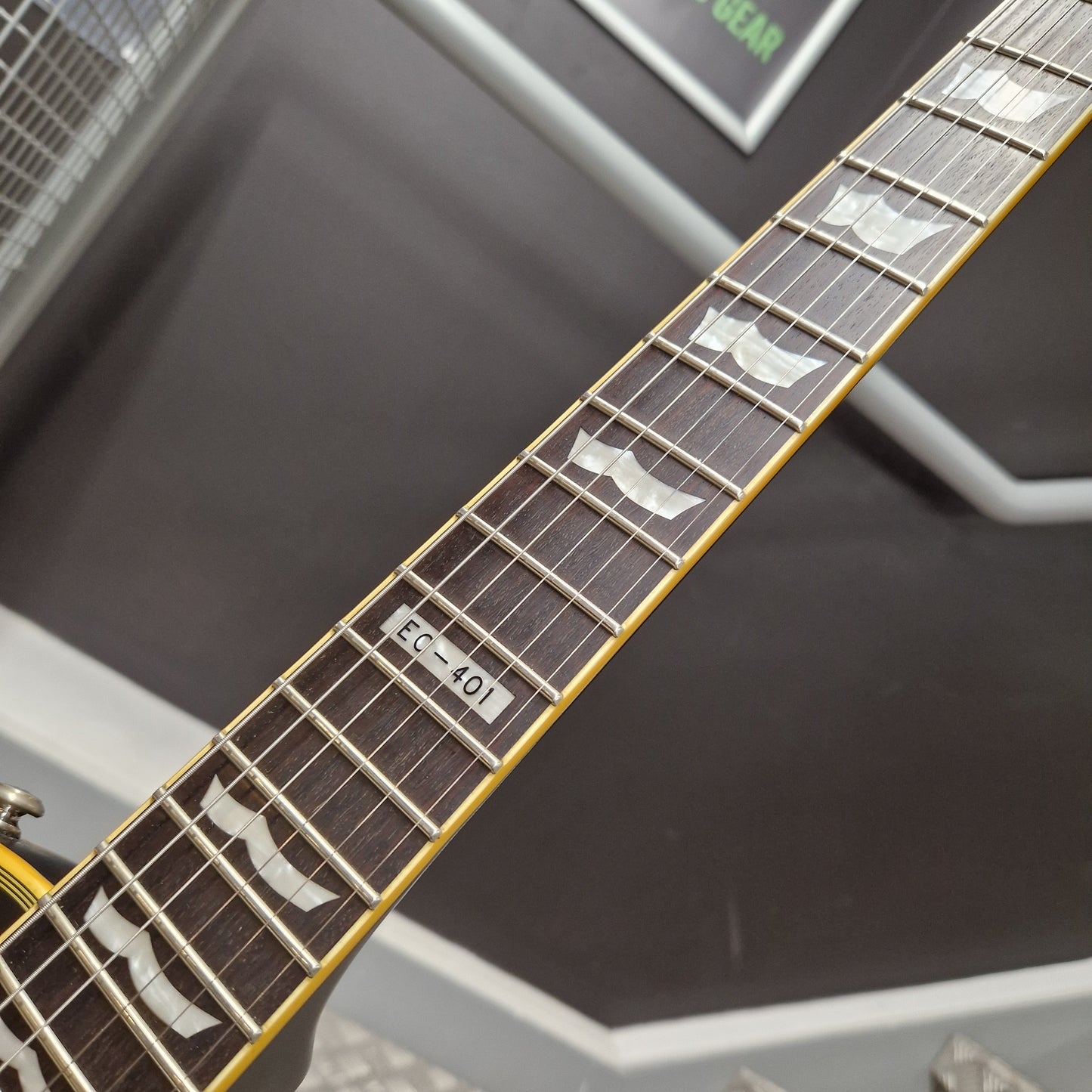 Pre-Owned ESP Close-up of a guitar neck with fretboard and tuning pegs against a blurred background