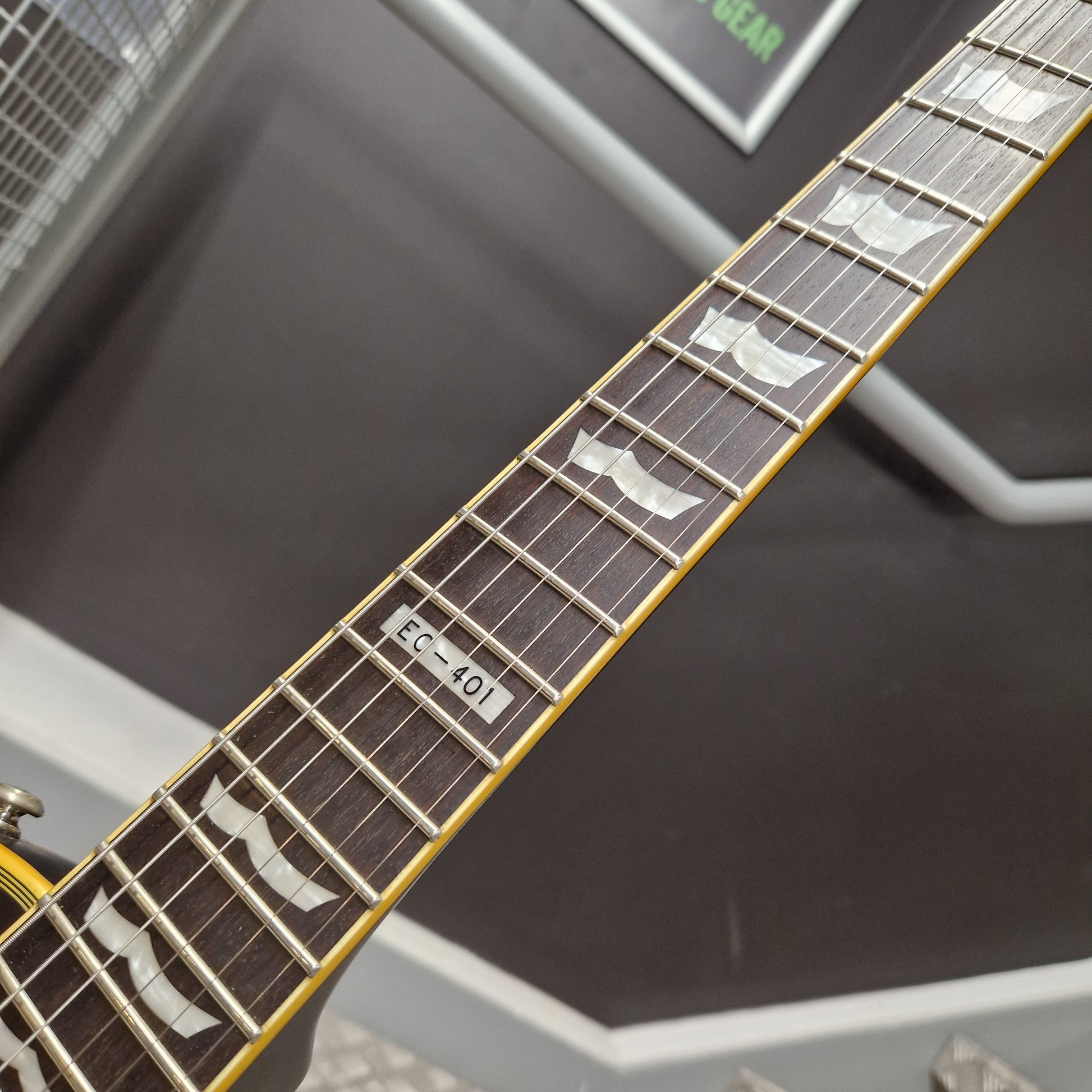 Pre-Owned ESP Close-up of a guitar neck with fretboard and tuning pegs against a blurred background