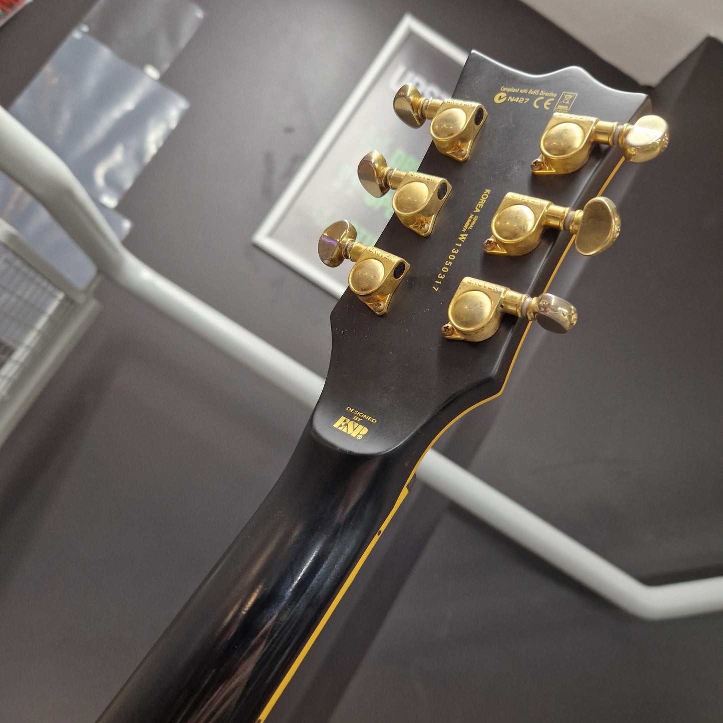 Pre-Owned ESP Close-up of a guitar headstock with tuning pegs on a blurred background