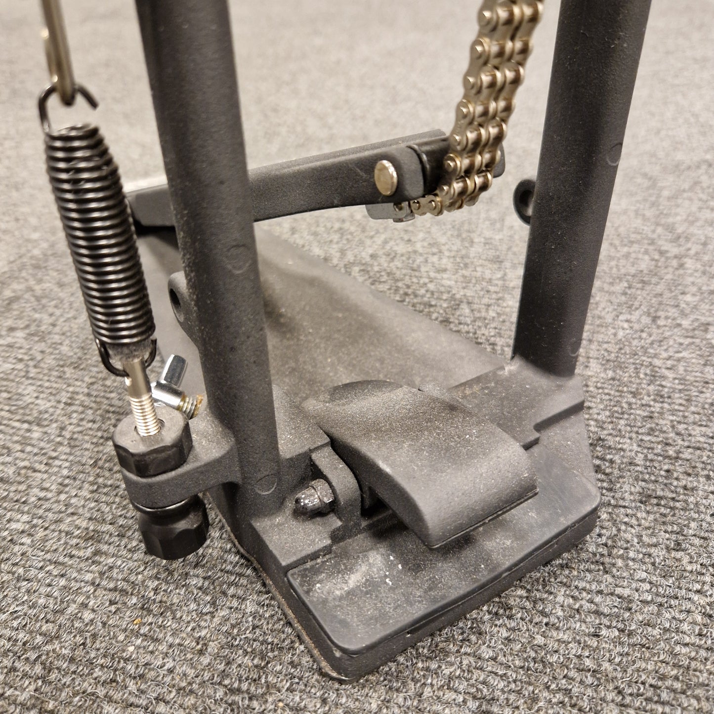 Pre-Owned Yamaha Close-up of a metal pedal with springs and a chain on a textured surface