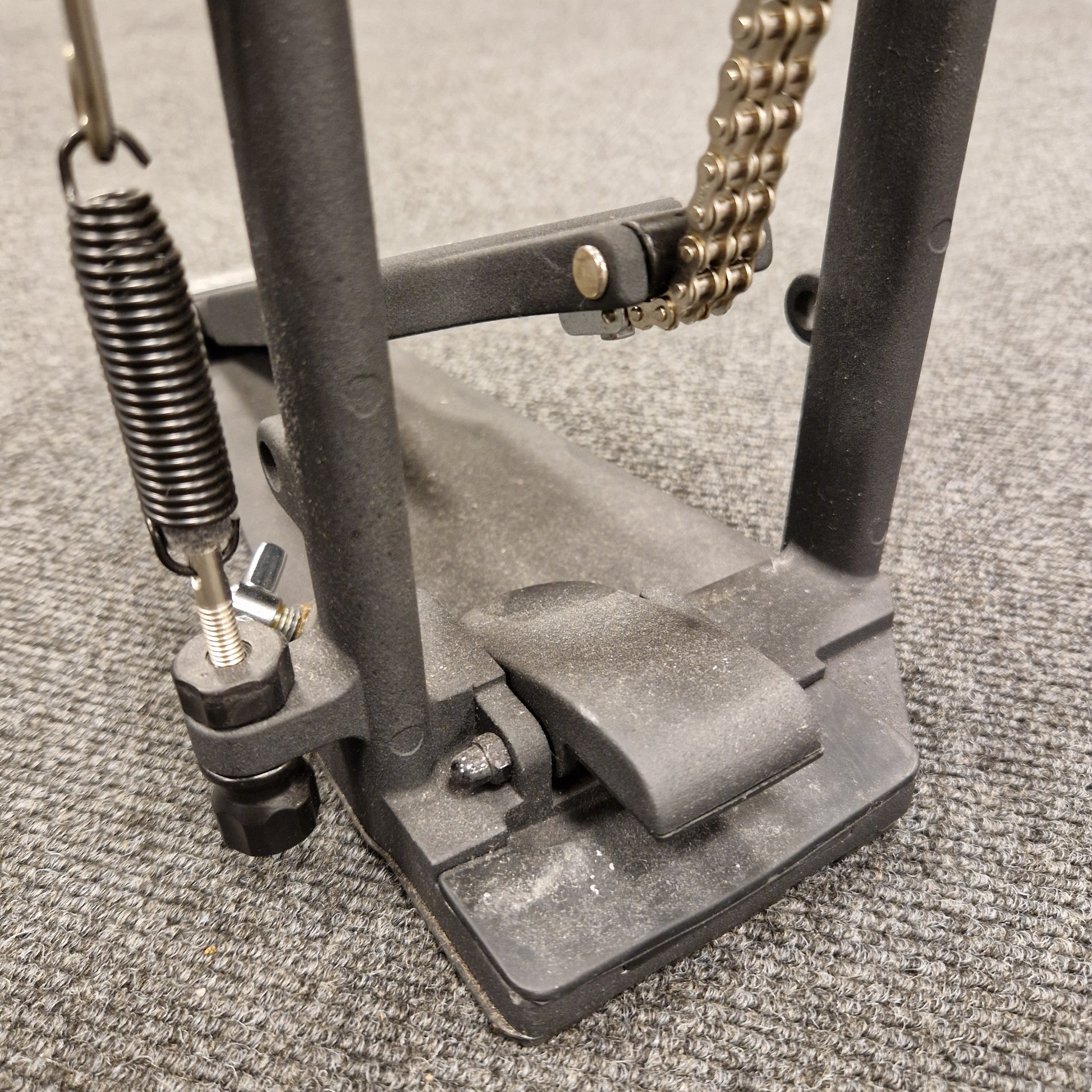 Pre-Owned Yamaha Close-up of a metal pedal with springs and a chain on a textured surface