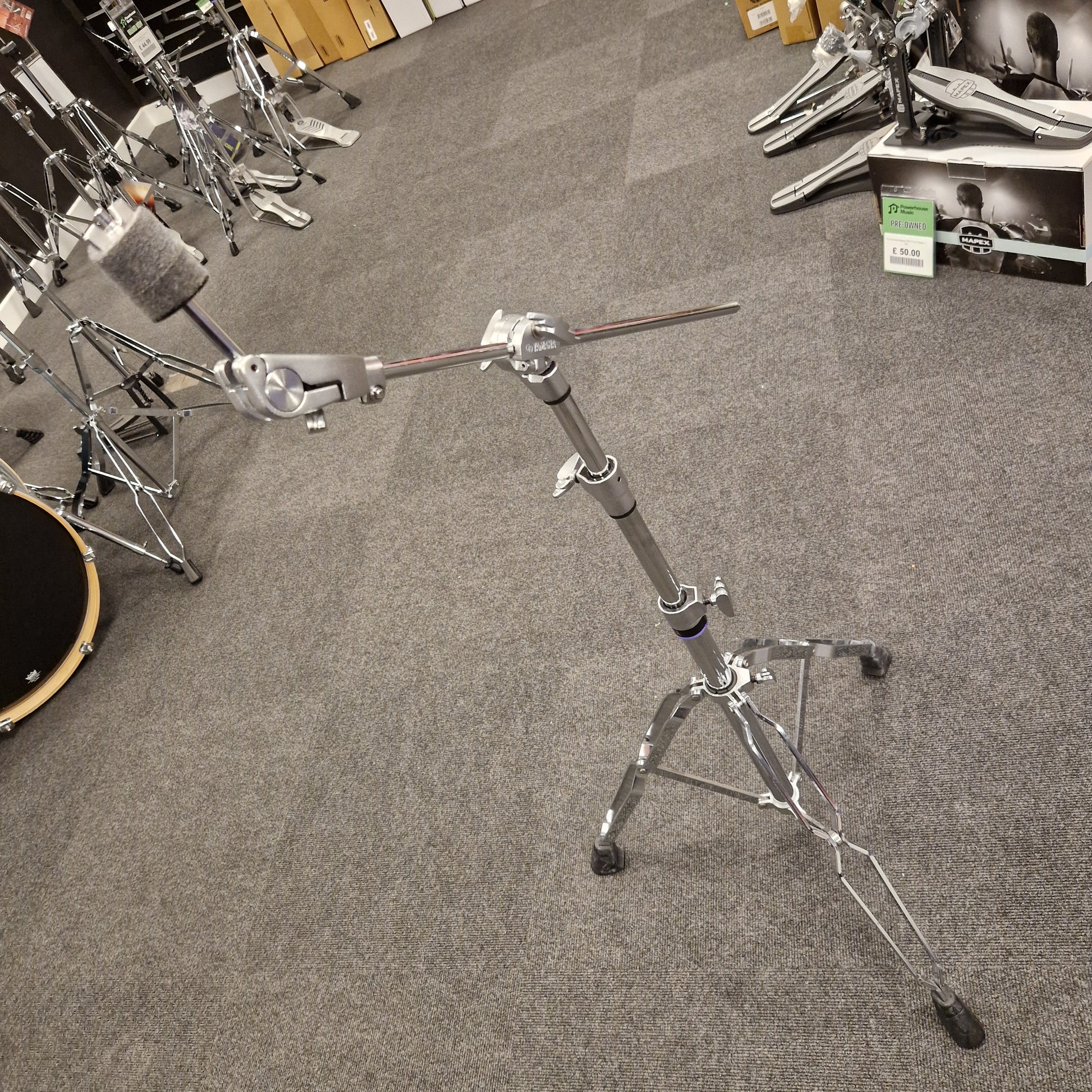 Pre-Owned Yamaha Drum stand on a gray carpeted floor with musical equipment in the background